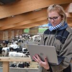 Eleveuse et ordinateur dans stabulation