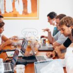 Groupe de jeunes avec ordinateur autour de table