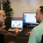 homme et femme devant ordinateur, discussion