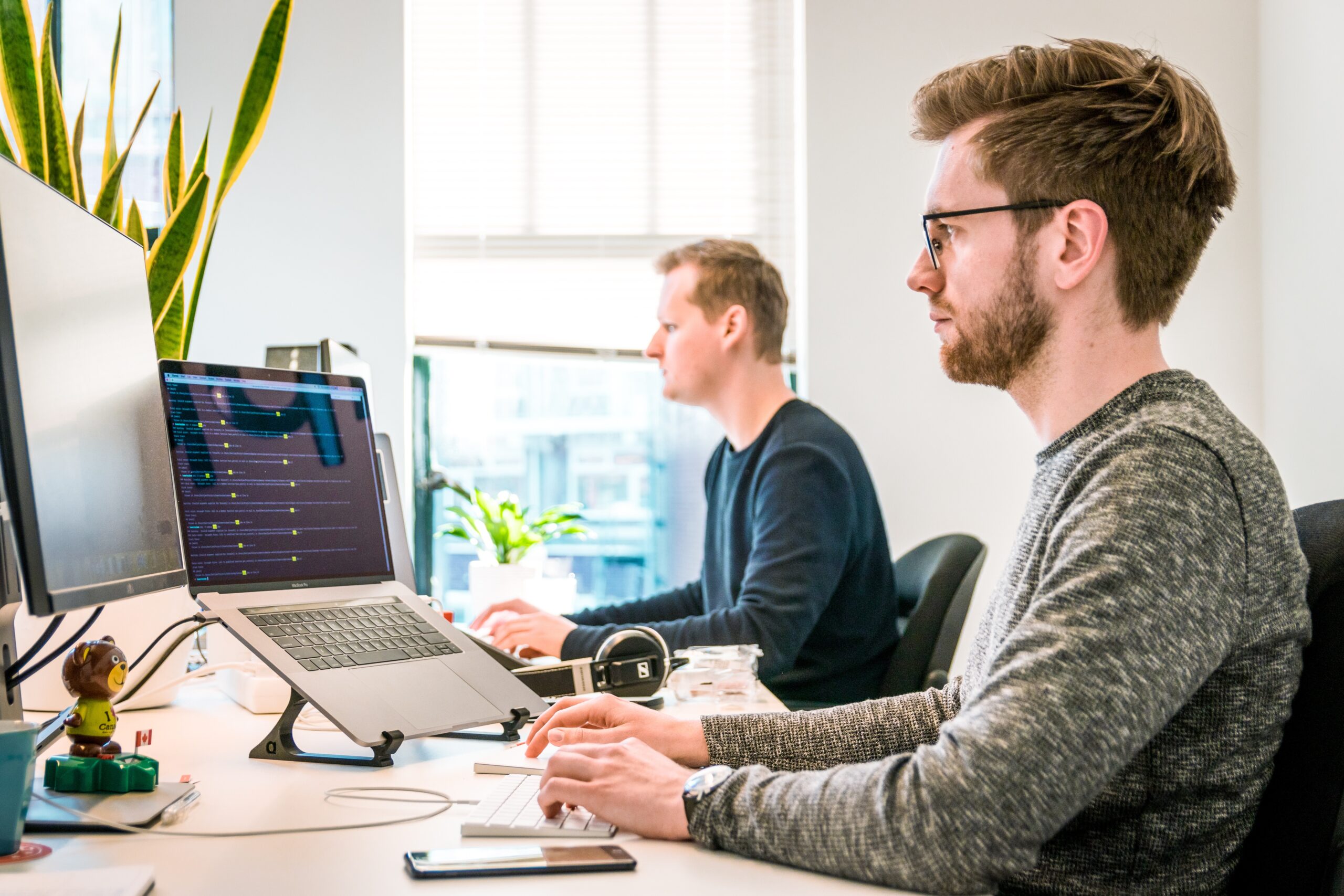 Deux jeunes devant ordinateurs, bureau