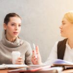 Deux femmes en formation, discussion, bureau, cahiers, réunion, marketing, travail