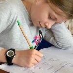 Fillette qui fait ses devoirs sur son cahier, mathématique, école